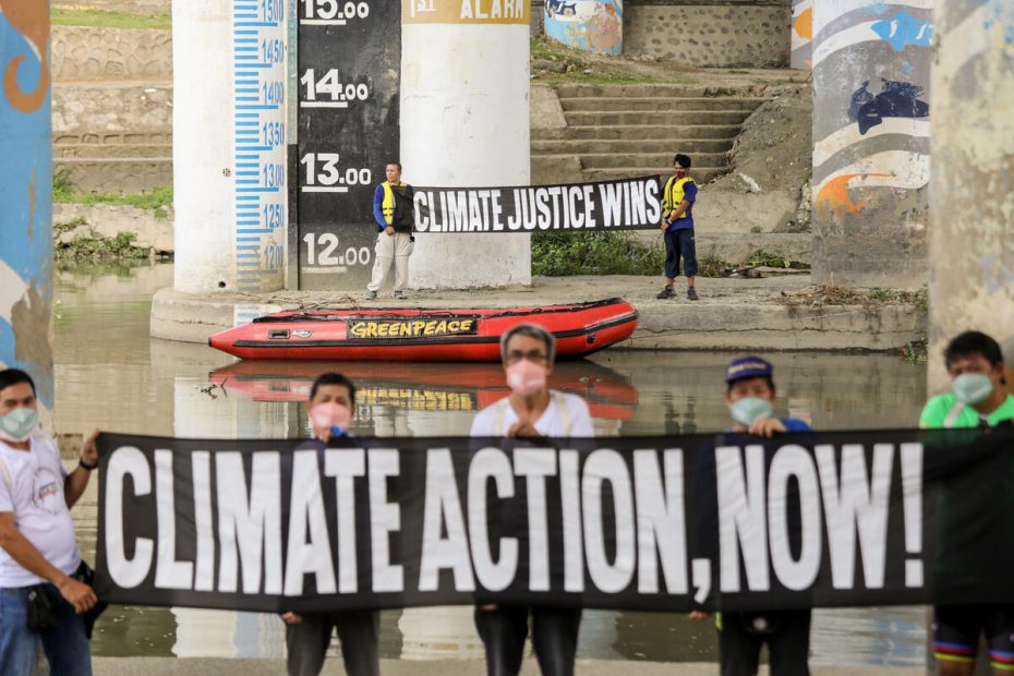 Greenpeace activists together with survivors of climate disasters carry banners during a protest beside the Marikina River flood level marker. The groups called on the government to stand for climate justice, ahead of the May 2022 national elections and after the #LetTheEarthBreathe movement made rounds online. Marikina is one of the hardest hit cities in the metro during typhoon season in the Philippines, where calamities have worsened resulting in heavy rains and severe flooding in various parts of the country. © Basilio H. Sepe / Greenpeace