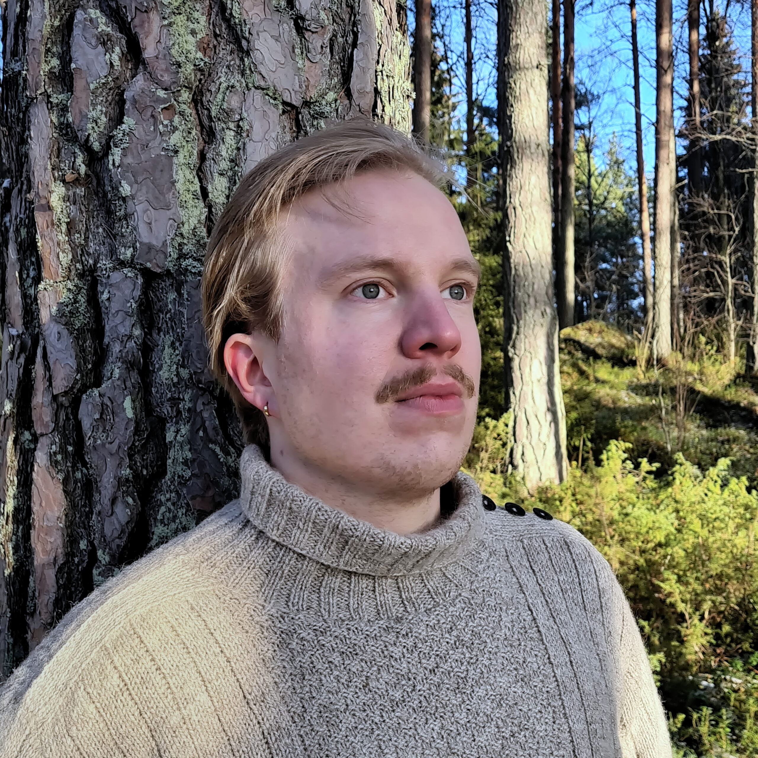 Aleksi Knaappila leaning against an old pine