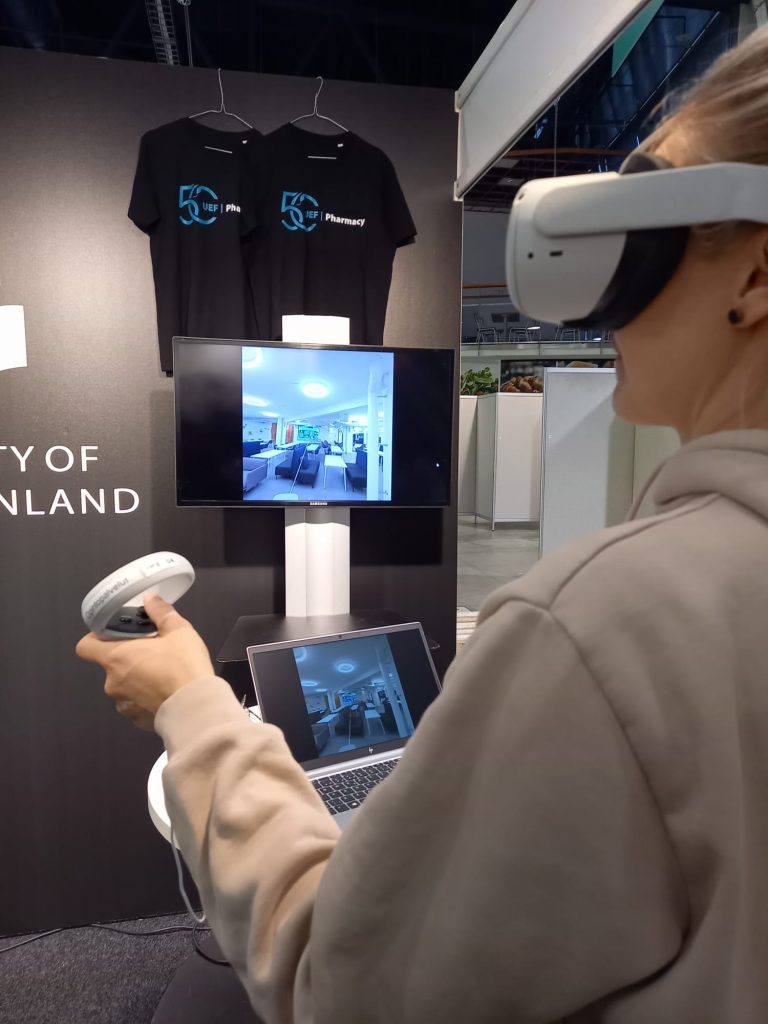 Kuvassa henkilö, joka tutustuu farmasian laitoksen ja Jatkuvan oppimisen keskuksen tiloihin virtuaalikierroksen kautta VR-laseilla.