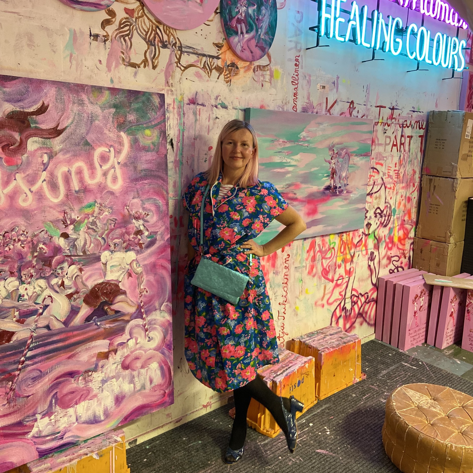 Katja Tukiainen standing in front of her pastel colored art