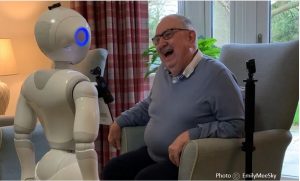 Picture of a robot engaging with an elderly man. Copyright EmilyMeeSky.