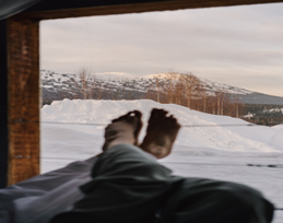 A person's feet with a snowy mountain in the background.