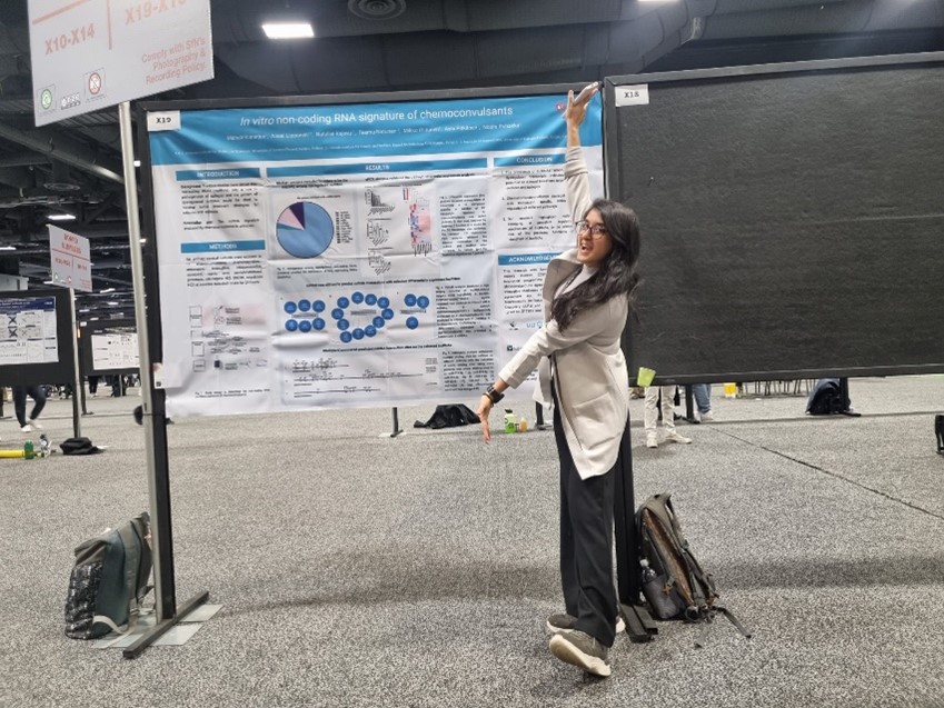Picture of Meheli Banerjee standing in front of her poster presentation.