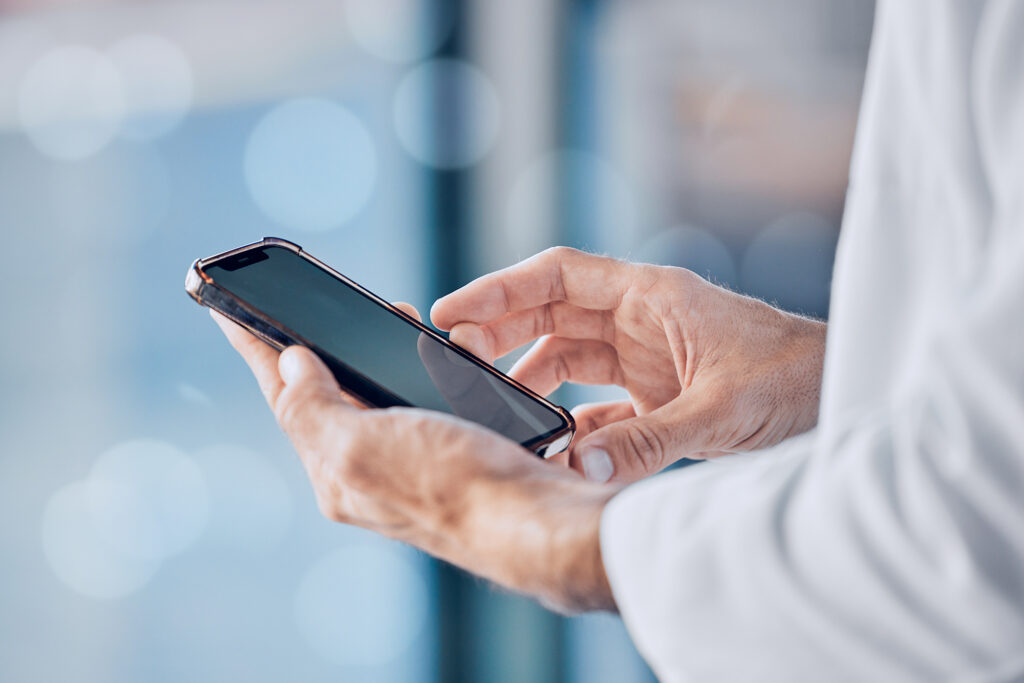 Closeup of medical professional or nurse on mobile smartphone app for networking or social media at clinic.